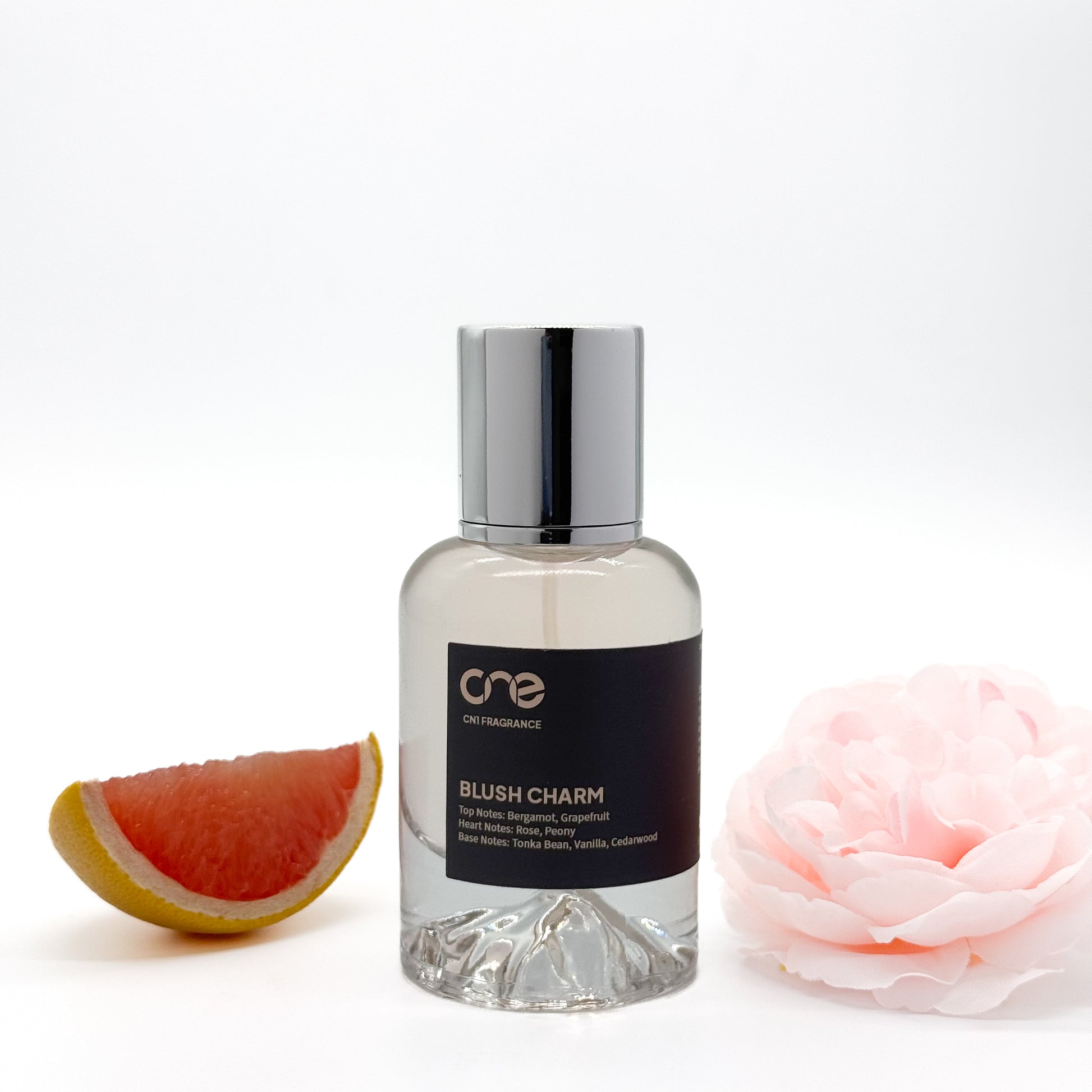 Blush Charm from CN1 Fragrance, showcasing an elegant blend of floral and fruity notes. With top notes of juicy pear and refreshing bergamot, heart notes of delicate rose and jasmine, and base notes of creamy vanilla and smooth musk, this fragrance exudes sophistication and charm.