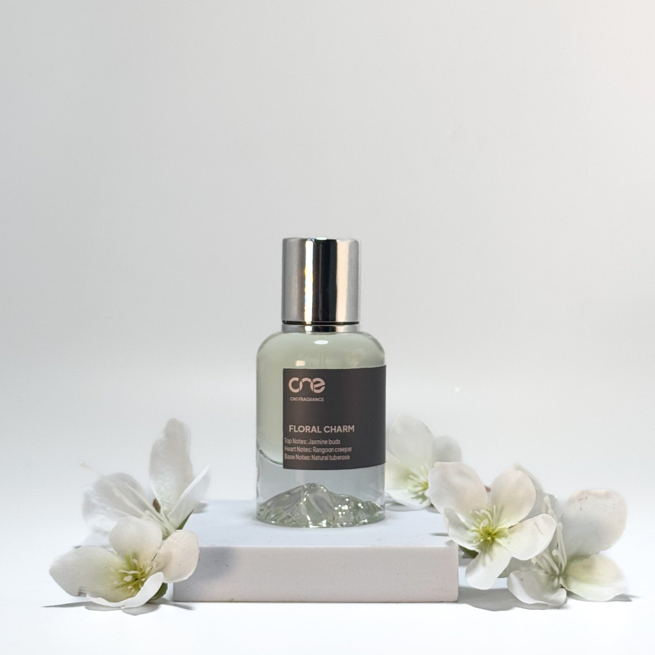 "Elegant bottle of Floral Charm by CN1 Fragrance, featuring a delicate and enchanting scent with top notes of bergamot and orange blossom, heart notes of jasmine and tuberose, and base notes of sandalwood and vanilla. Perfect for adding a touch of elegance to any occasion