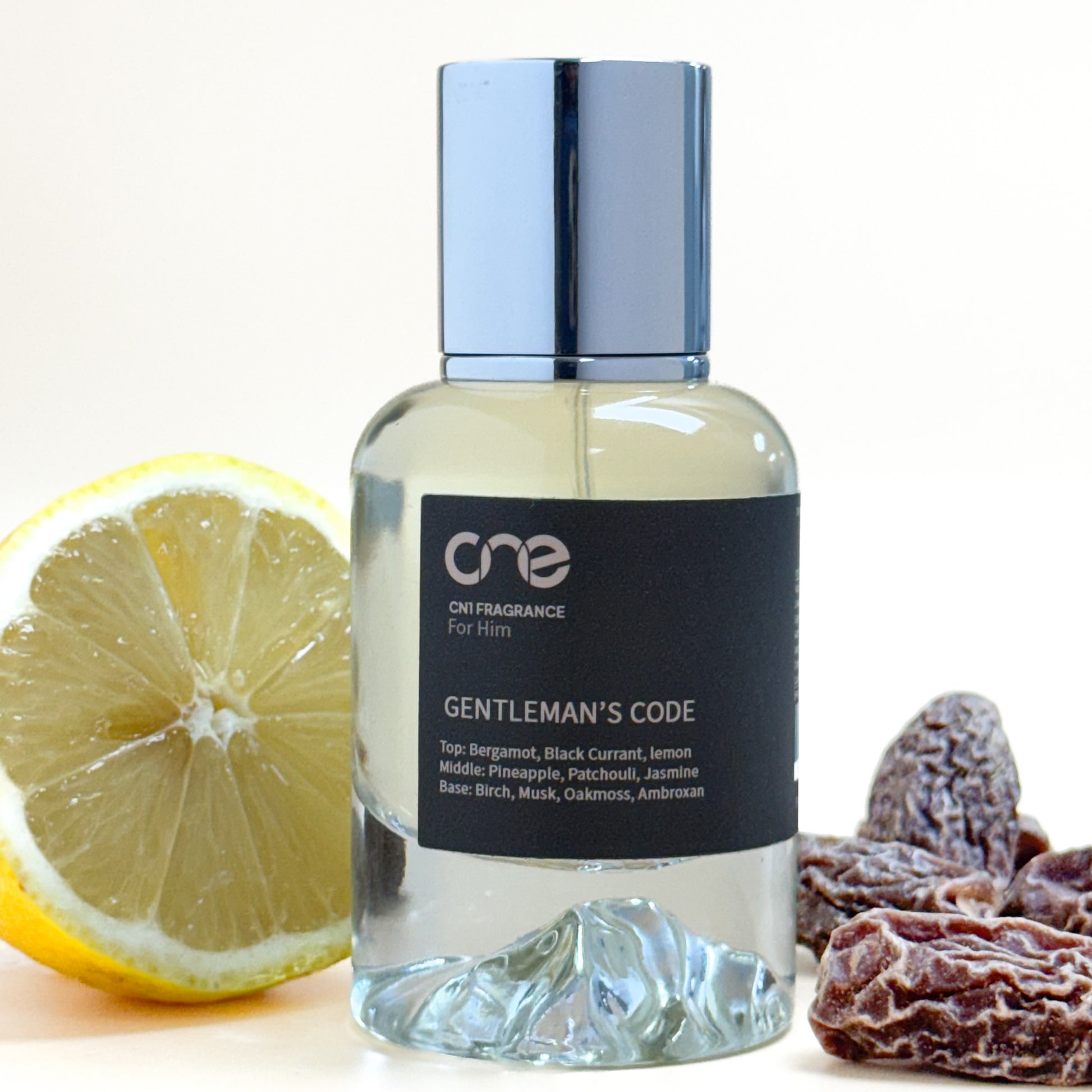 Bottle of 'Gentleman's Code' fragrance with a lemon and dried fruits on a white background