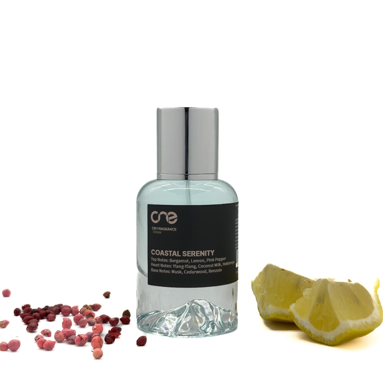 Coastal Serenity by CN1 Fragrance 50 ml clear bottle with pale blue liquid and silver cap on a sandy shore background