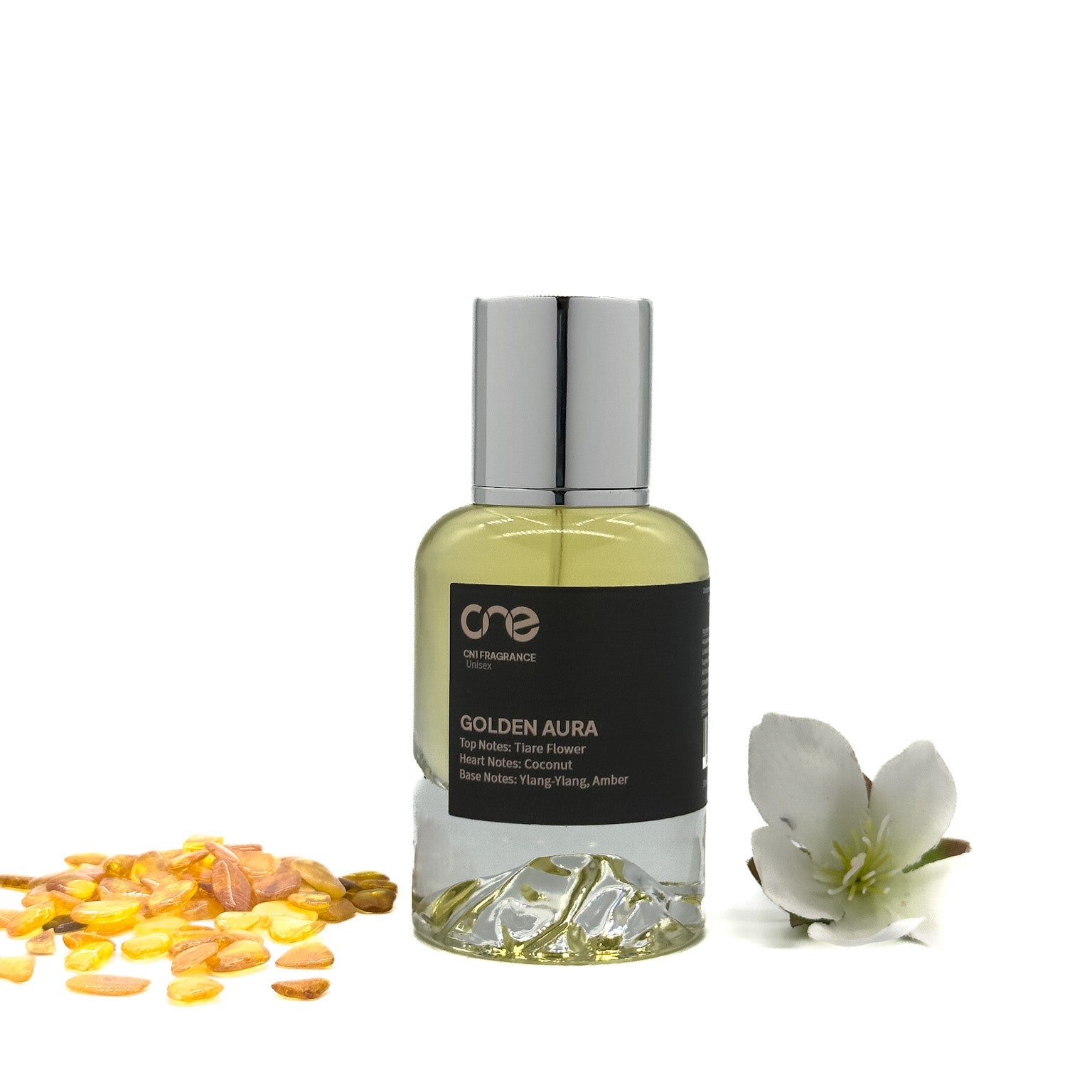 Golden Aura by CN1 Fragrance 50 ml clear glass bottle with golden liquid and silver cap, surrounded by tiare flowers and coconut pieces on white marble