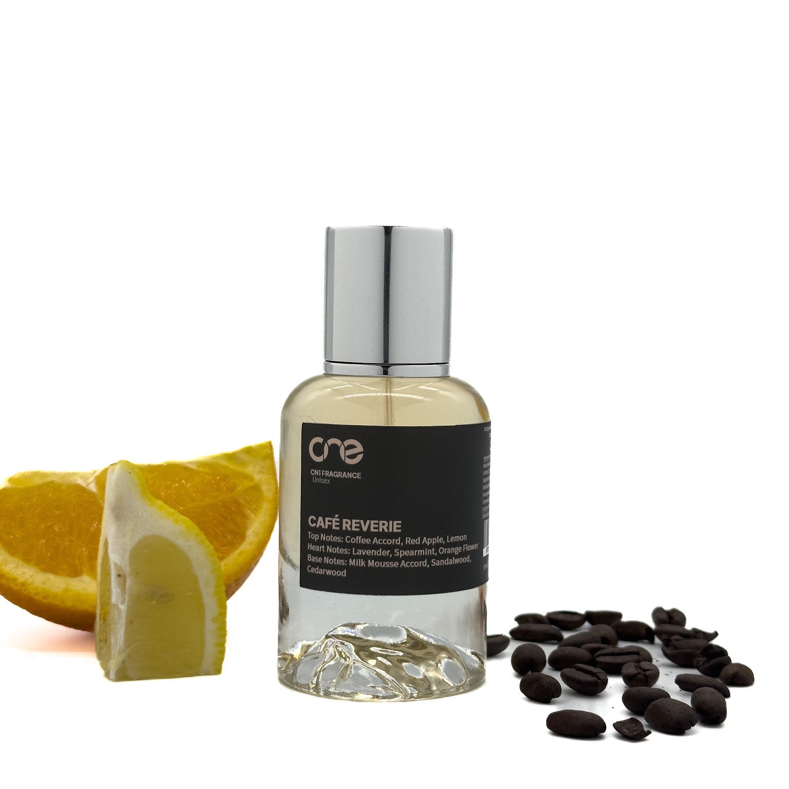 Café Reverie by CN1 Fragrance 50 ml clear glass bottle with amber liquid, surrounded by coffee beans and vanilla pods on a rustic wooden table