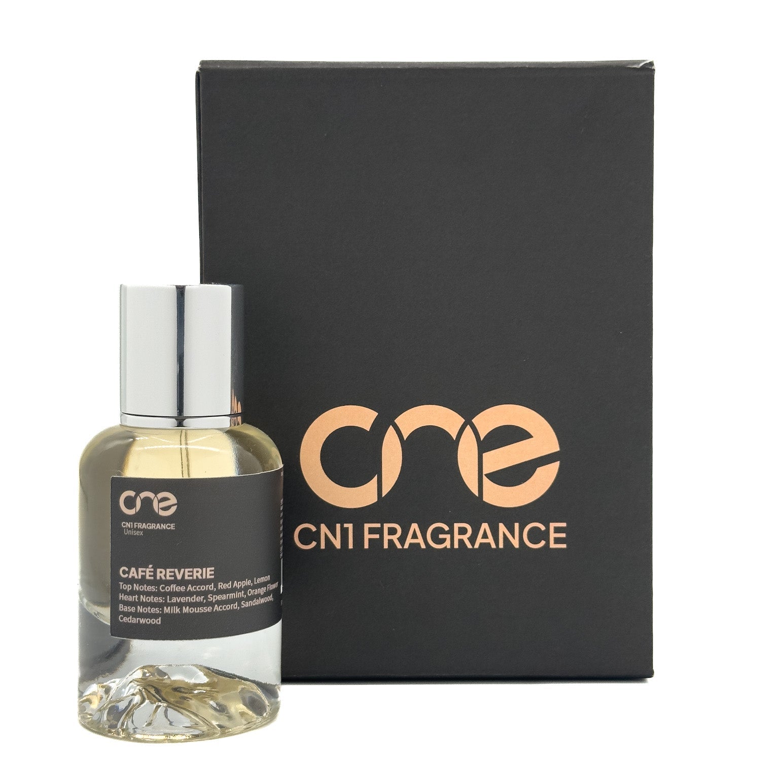 Café Reverie by CN1 Fragrance bottle on marble countertop with scattered coffee beans and a latte cup in soft natural light