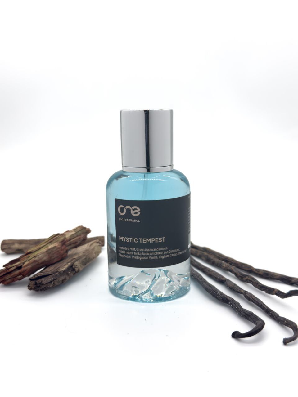 Mystic Tempest by CN1 Fragrance 50 ml clear glass bottle with golden liquid, styled with mint leaves, green apple slices, and lemon wedges on a marble surface.